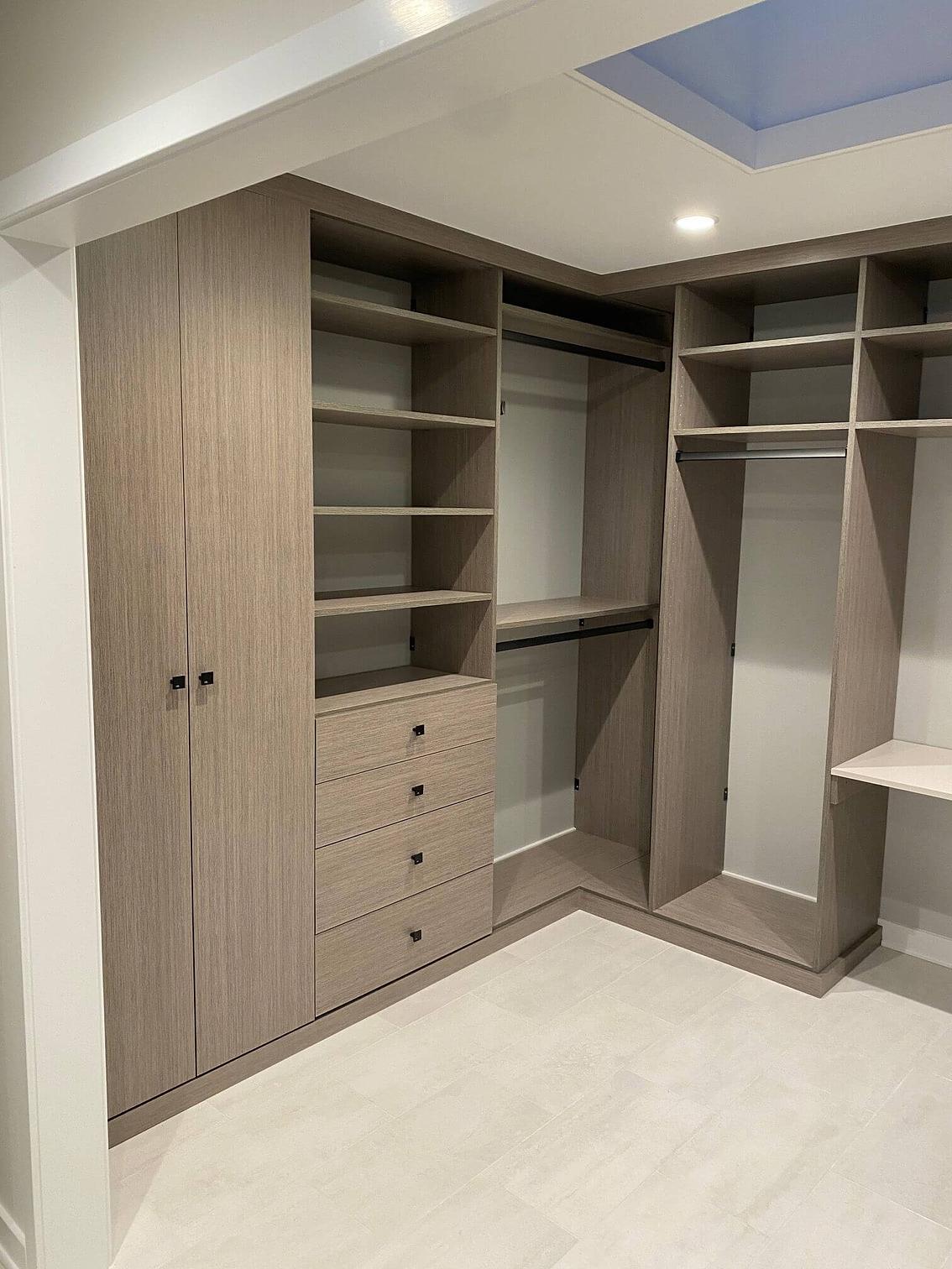 Beautiful light walk-in closet with cabinets, drawers, shelving, and closet rods