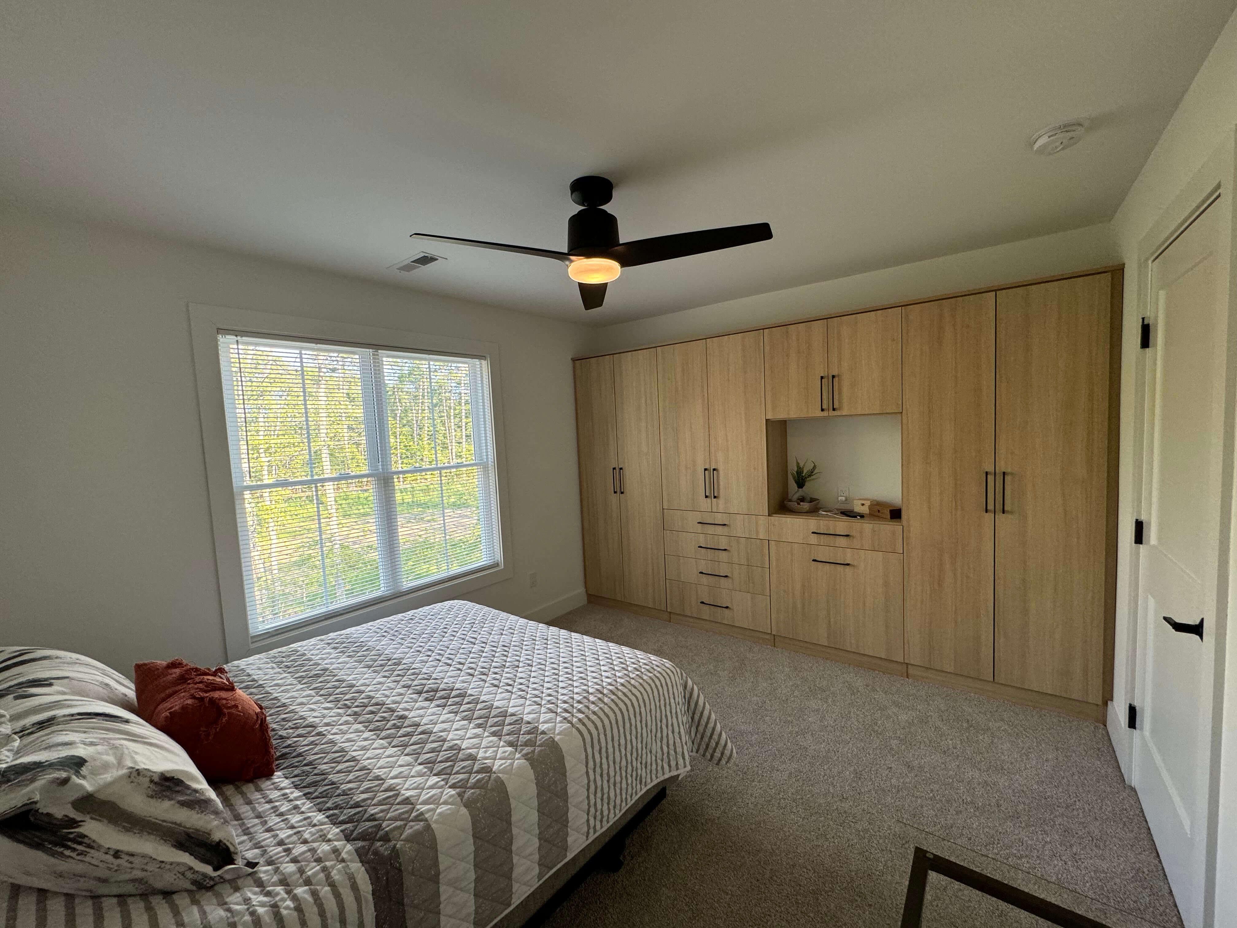 Floor to ceiling natural wood entertainment center with drawers and cabinets in Richmond, VA