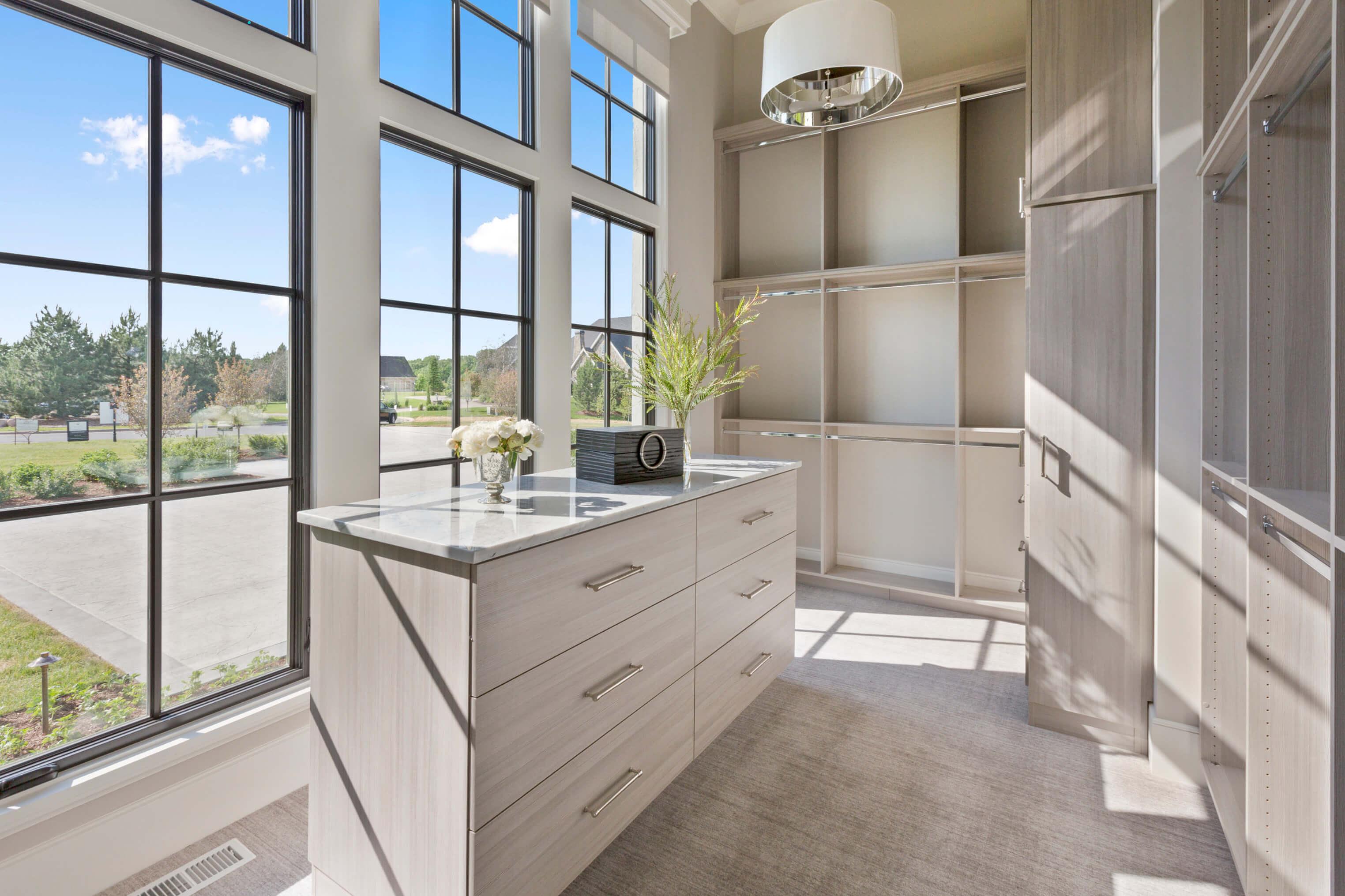 Naturally lit walk-in closet with center island